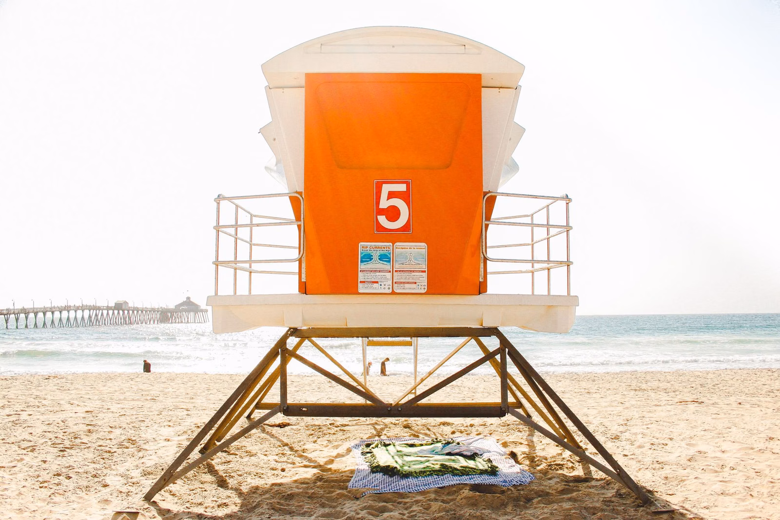 A San Diego County beach lifeguard tower on the sand with the ocean behind