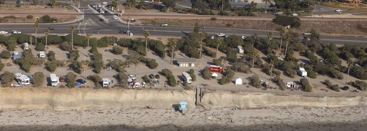 RVs and trailers parked in campsites on the bluff at San Elijo State Beach